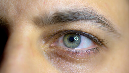 Macro of a man's eye while working on the computer.