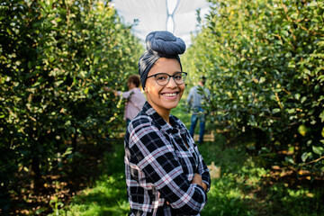 Portrait of young female african american farmer in orchard.