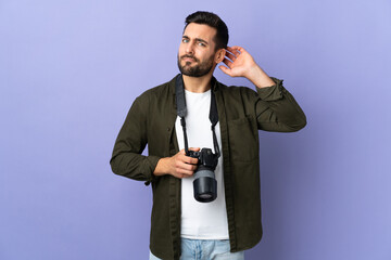 Photographer man over isolated purple background having doubts