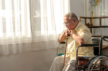 Lonely Asian Senior man was sick and sitting on wheelchair. Retirement age lifestyle and stay at...