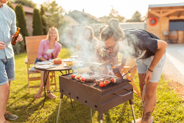 People relaxing at poolside barbecue party