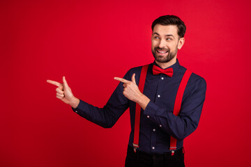 Naklejka premium Photo of young handsome cheerful smiling gentleman point finger copyspace advertisement isolated on red color background