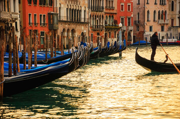 Fototapeta na wymiar Venice, Italy. Gondola with unrecognizable gondolier departing from the pier. Romantic landscape.