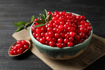 Tasty ripe cranberries on black wooden table, closeup