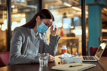 Tired young woman sitting at her workplace