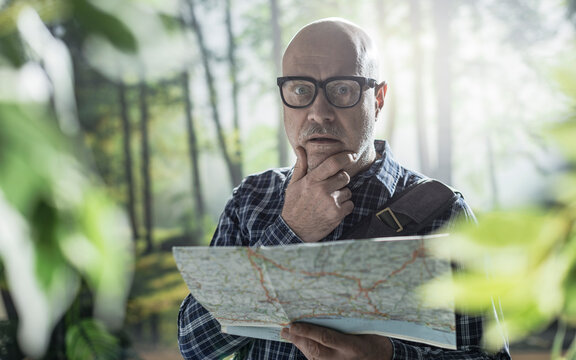 Tourist lost in the forest checking a map