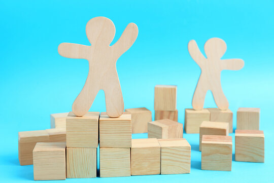 Wooden Cubes And Human Figures On Light Blue Background. Social Roles Concept