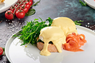 Toast with salmon, poached egg and hollandaise sauce.. Classic breakfast with salmon on a white...