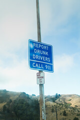 A blue road sign that reading "Report drunk drivers, call 911" in San Francisco, California - United states of America aka USA
