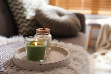 Obraz na płótnie Canvas Aroma candles on grey sofa indoors. Interior design