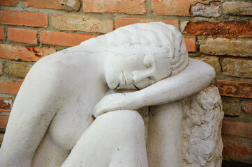 Sleeping girl statue at the entry to the marble workshop. Closeup. Venice everyday life. Venice, Italy