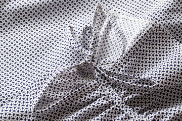 Variegated beautiful fabric from a blouse, lace tying a sleeve, close-up.