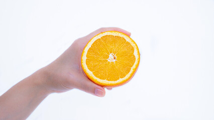 A woman's hand holds a ripe orange in her palm. Orange fruit in hand Isolated on white background