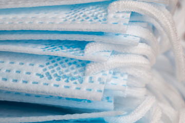 Textured surface white-blue medical masks with side ties closeup