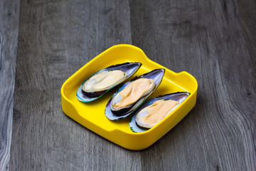 fresh mussels sliced on square plate  on wood, wooden background,set shabu, hot pot ingredients.