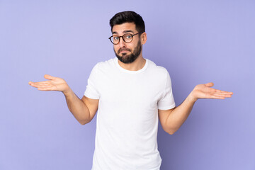 Caucasian handsome man over isolated background having doubts while raising hands