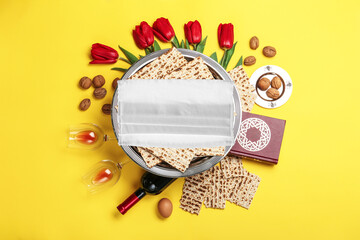 Coronavirus pandemic. Flat lay composition with Passover matzos and protective face mask on yellow background