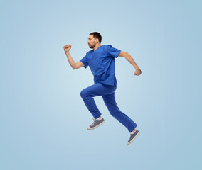 healthcare, profession and medicine concept - doctor or male nurse in uniform jumping in air over...