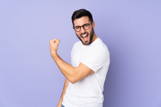 Caucasian handsome man over isolated background celebrating a victory