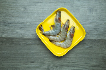 fresh raw shrimp sliced on square plate  on wood, wooden background,set shabu, hot pot ingredients.