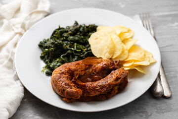 typical portuguese smoked sausage alheira with chips and greens