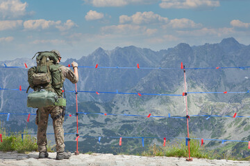Army man enjoying the view on mountain top, Active hiker hiking, enjoying the view, looking at mountain landscape.