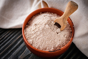 fresh natural buckwheat flour on a dark wooden rustic background culinary concept