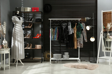 Rack with collection of beautiful festive clothes in stylish room interior