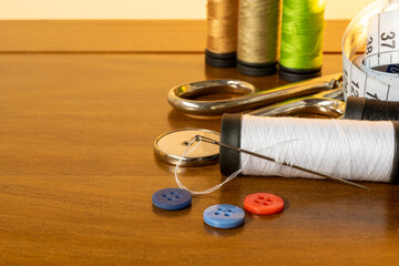 sewing trims. spool of thread, needle, buttons, scissors and measuring tape. With space for text....