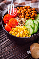 bowl of healthy quinoa with vegetables on a dark rustic background