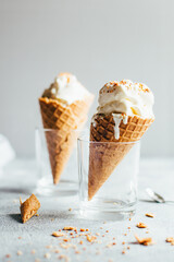 close-up of two white ice creams in waffle cups on gray background