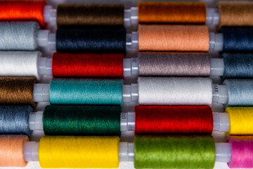 Colored sewing threads are in a row