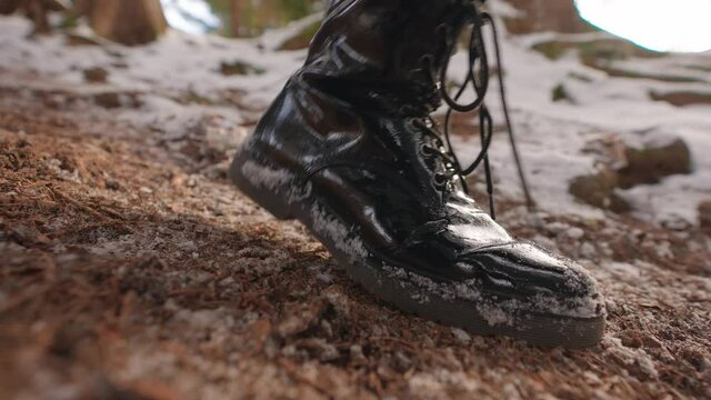 Close up of shoes walking over a soft wooden ground in a snow environment