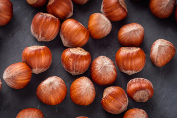 fresh natural hazelnuts on a dark stone background