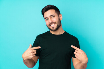 Caucasian handsome man isolated on blue background proud and self-satisfied