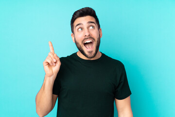 Caucasian handsome man isolated on blue background intending to realizes the solution while lifting a finger up