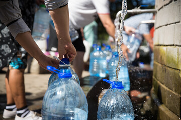 Fototapeta premium Collecting natural spring water with 5 litre plastic water bottle at Newlands natural spring Cape Town South Africa