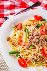 delicious traditional Italian pasta with tuna on a white rustic wooden background