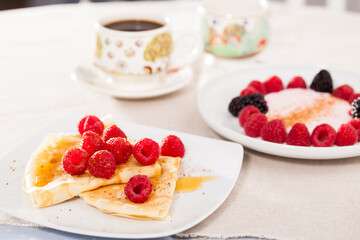 breakfast of pancakes with fresh raspberries on table