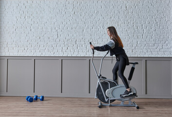 Training sportive woman at home, doing sport interior concept, decorative background and ride a bike style.