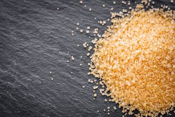 cane brown sugar on a dark stone background