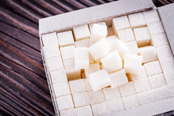 sugar refined on a dark rustic wooden background