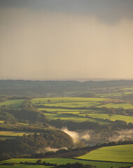 Rural landscape with field and sky. Low clouds in the valley. Sunrise sunset.