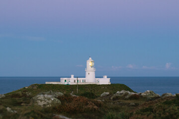 Fototapeta na wymiar Lighthouse on the coast at sunrise.