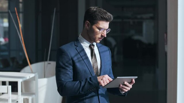 Urban businessman using digital tablet standing in the street