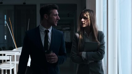 Businessman and woman leaving coffee shop, talking