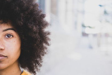 portrait of half a face of one young beautiful African or American woman looking at the camera....