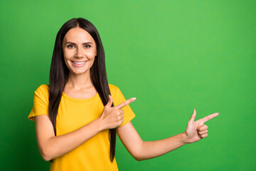 Photo of young woman happy smile point fingers empty space recommend advert promo select isolated over green color background