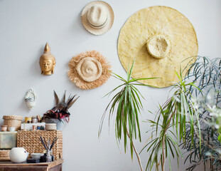 Hanging straw hats on white wall