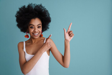 Happy african american girl smiling and pointing fingers upward